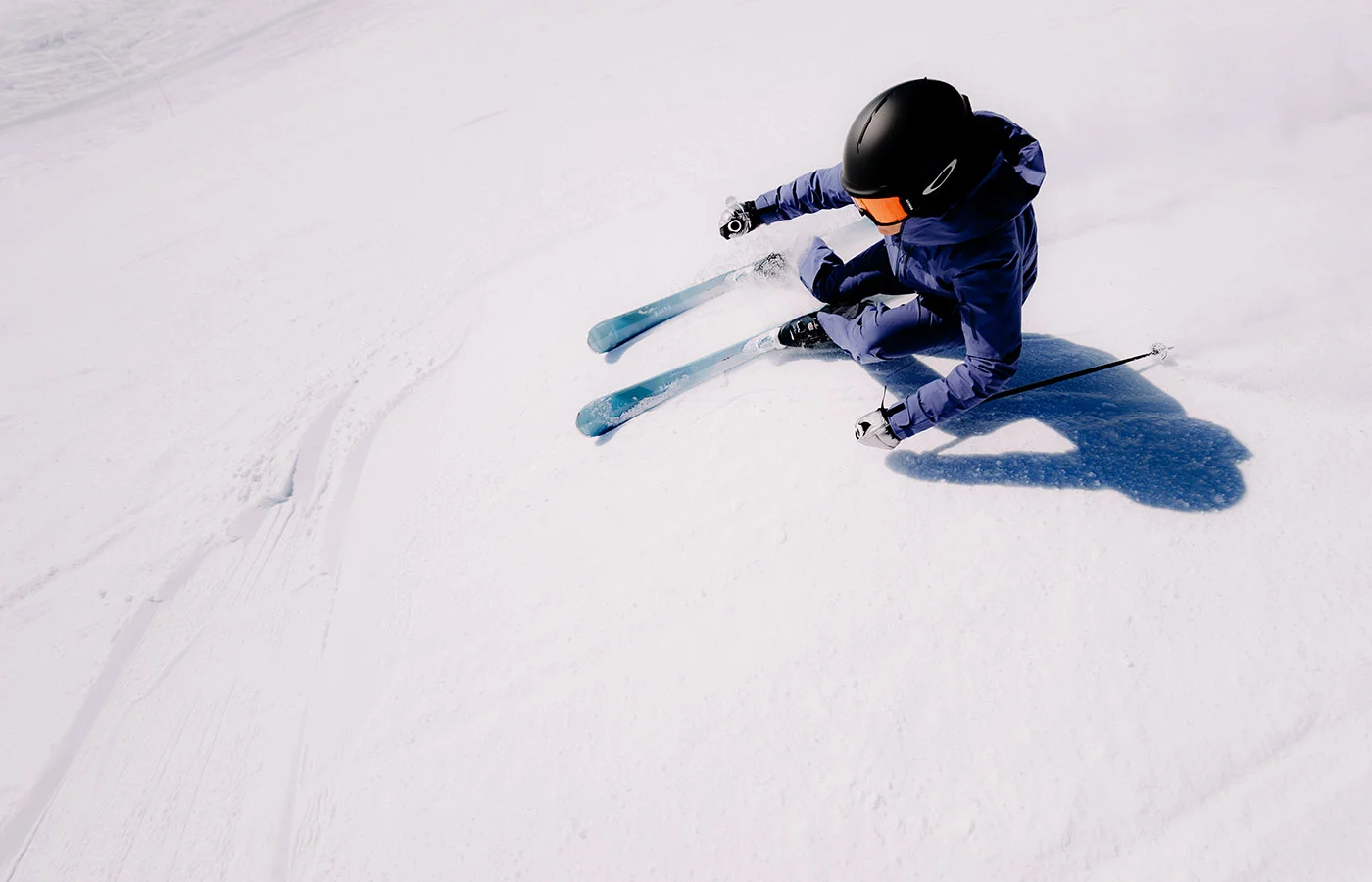 Skifahrerin in tiefer Kurvenlage aus der Vogelperspektive – Skitechnik und Carving