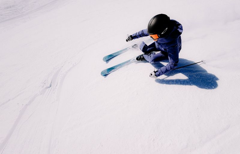 Skifahrerin in tiefer Kurvenlage aus der Vogelperspektive – Skitechnik und Carving