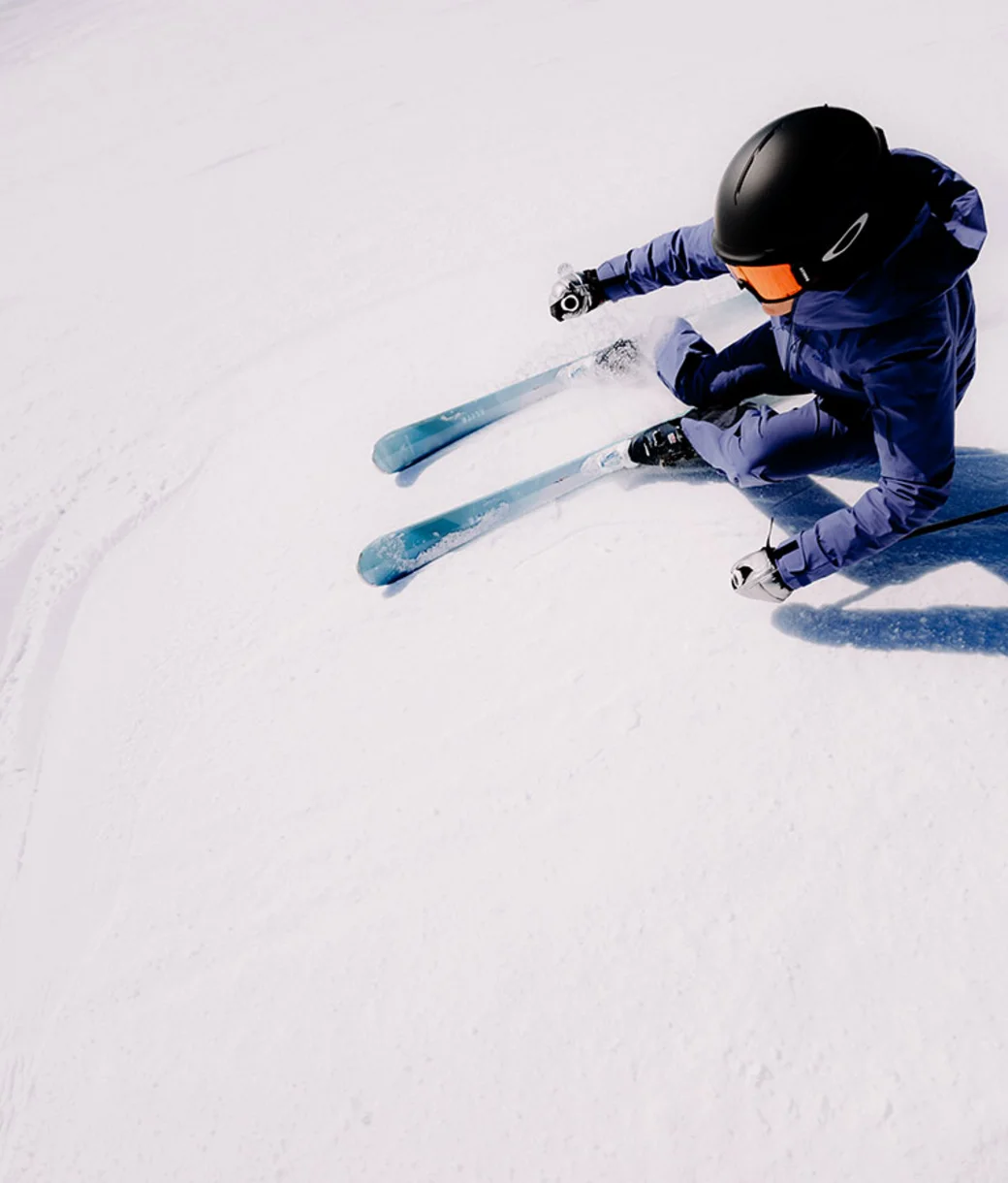 Skifahrerin in tiefer Kurvenlage aus der Vogelperspektive – Skitechnik und Carving