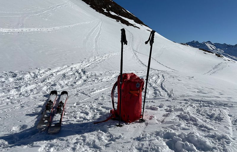 Rucksack, Skistöcke und Tourenski im Schnee – Ausrüstung für Skitouren
