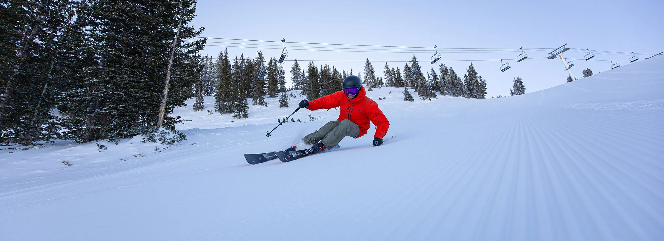 Skifahrer mit tiefer Kurvenlage beim Carving auf präparierter Piste