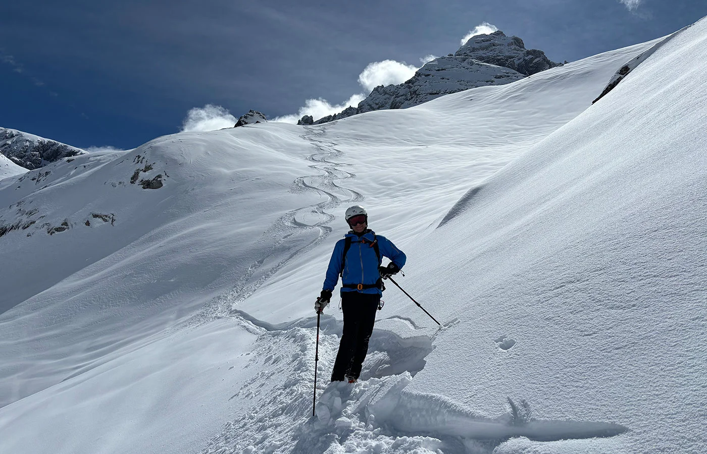 Skitourengeher neben seiner Spur im unverspurten Tiefschneehang