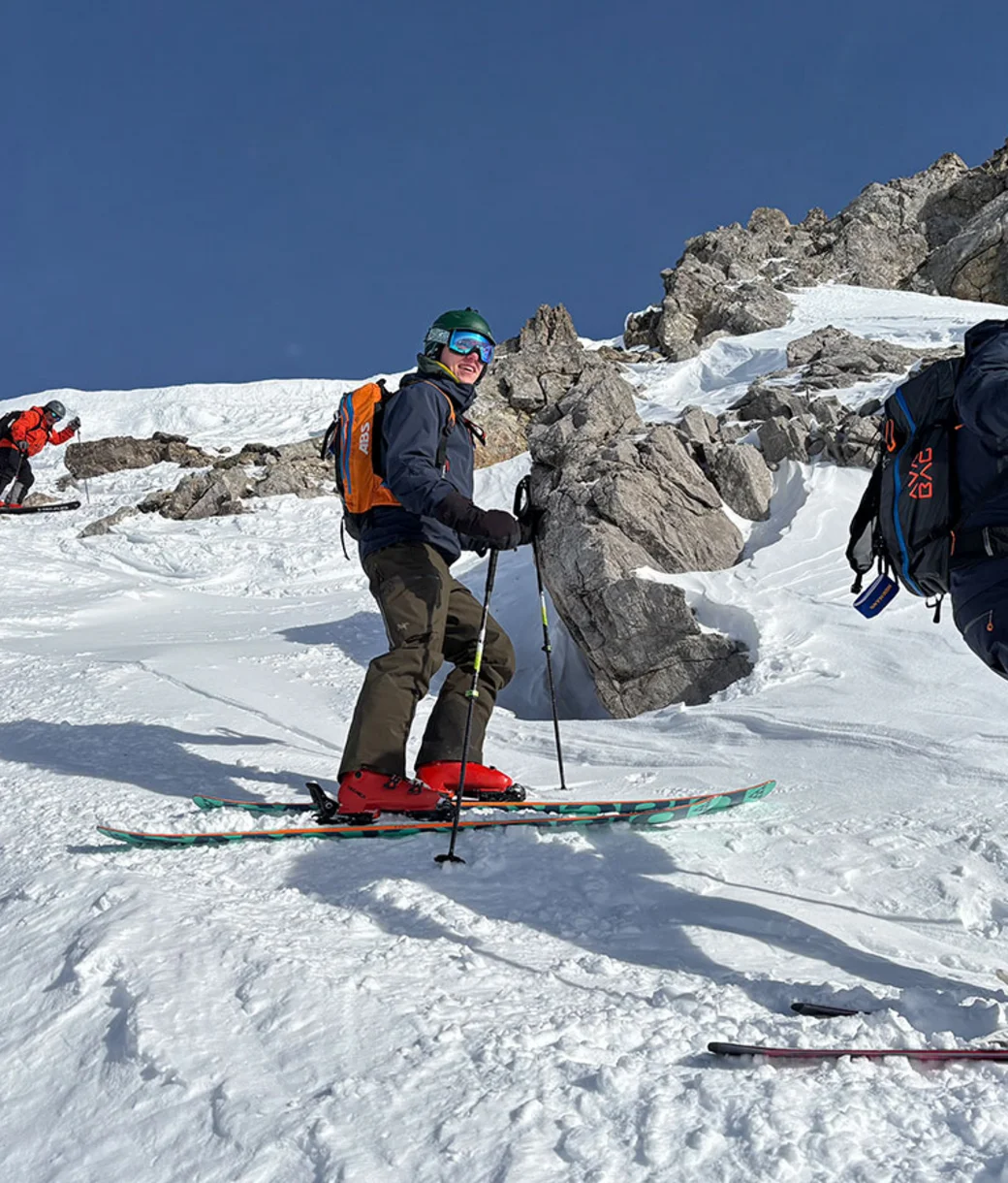 Skitourengruppe mit Rucksäcken im felsigen Hochgebirge
