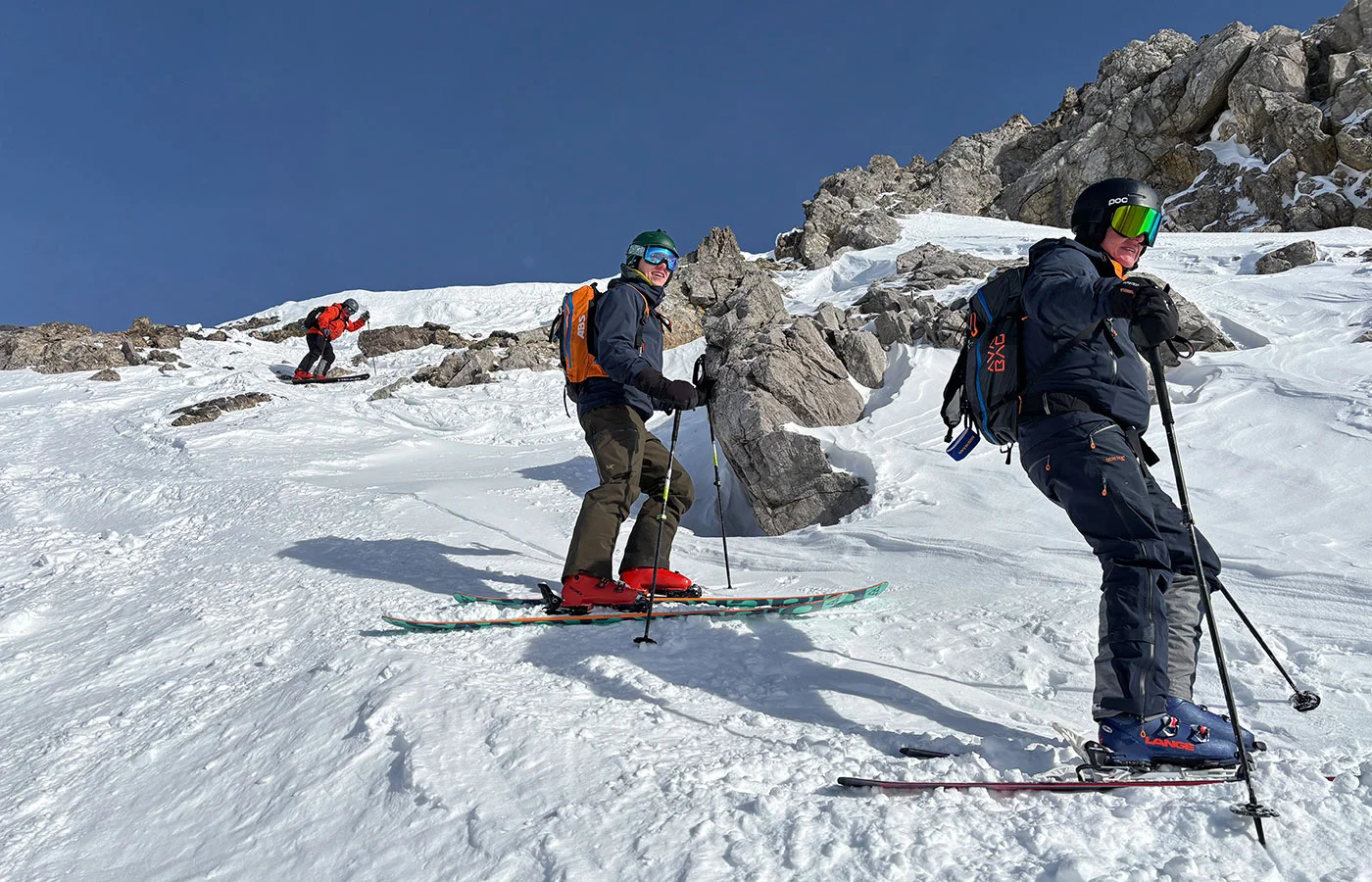 Skitourengruppe mit Rucksäcken im felsigen Hochgebirge