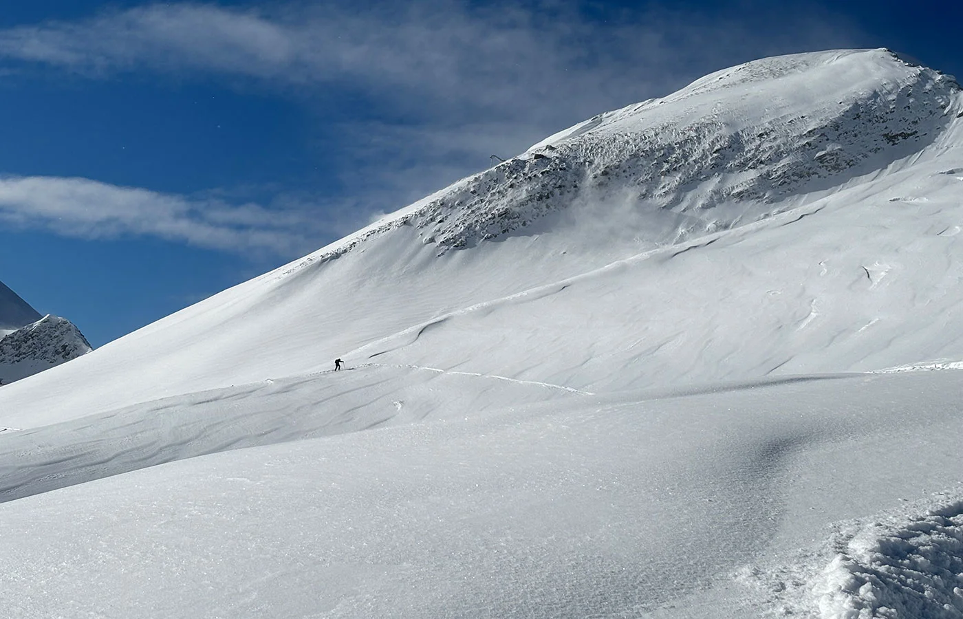 Weiter Schneehang mit Aufstiegsspur – Gelände beurteilen im Gebirge