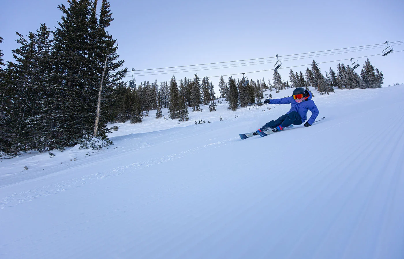 Skifahrerin mit extremer Kurvenlage beim Carving auf der Piste