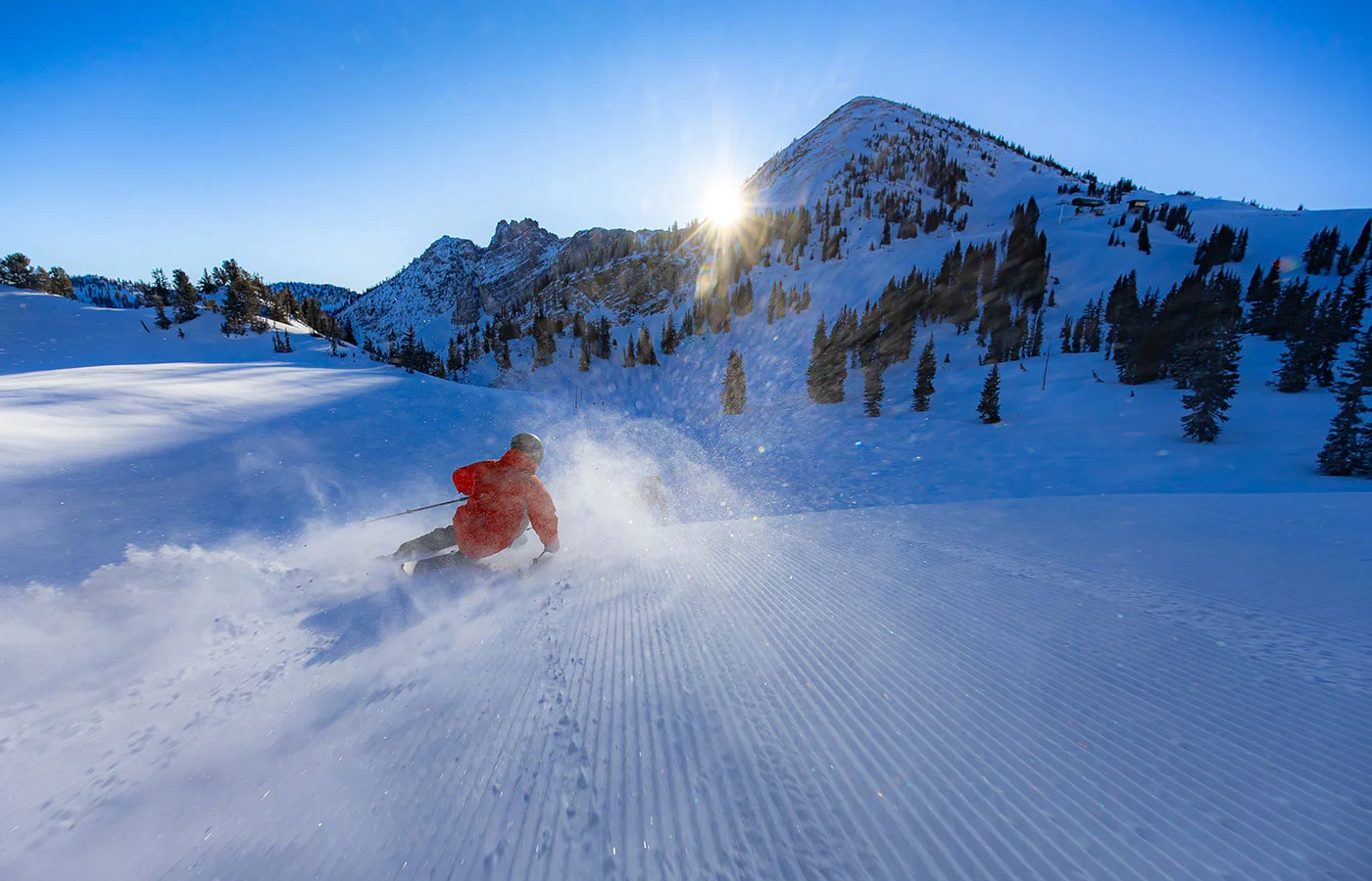 Skifahrer im Gegenlicht beim Schwung auf präparierter Piste